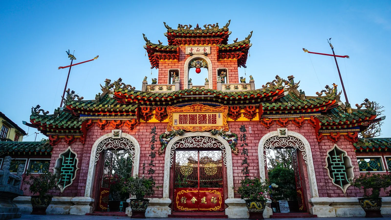 Mặt tiền hội quán màu đỏ với mái chạm rồng tinh xảo tại Hội An.