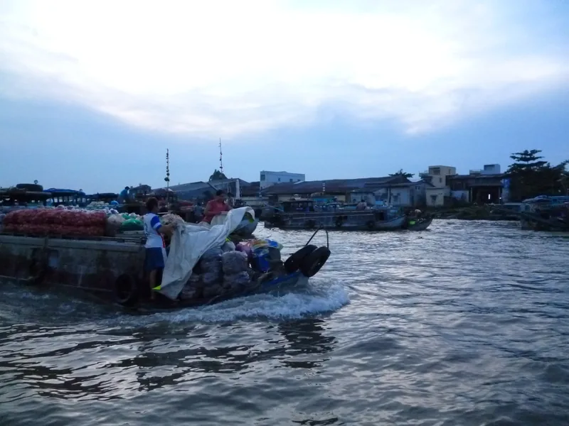 Một chiếc ghe chở đầy hàng hóa lướt trên sông ở chợ nổi Cái Răng gần Cần Thơ lúc chạng vạng.