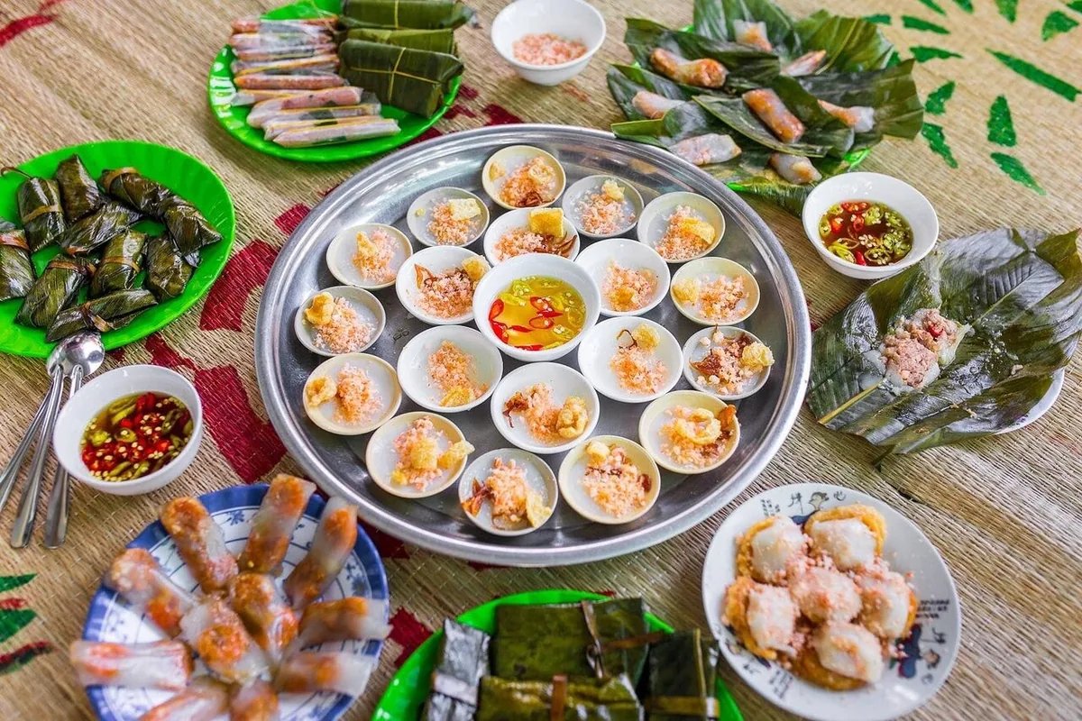 Mâm các món ăn đặc sản Huế gồm bánh bèo, nem cuốn và nước chấm được bày trên chiếu cói.